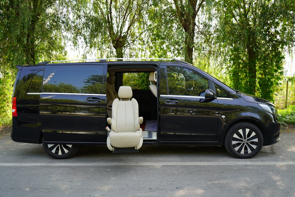 A luxurious black van with an elegant leather seat exposed outdoors, highlighting accessibility and comfort.
