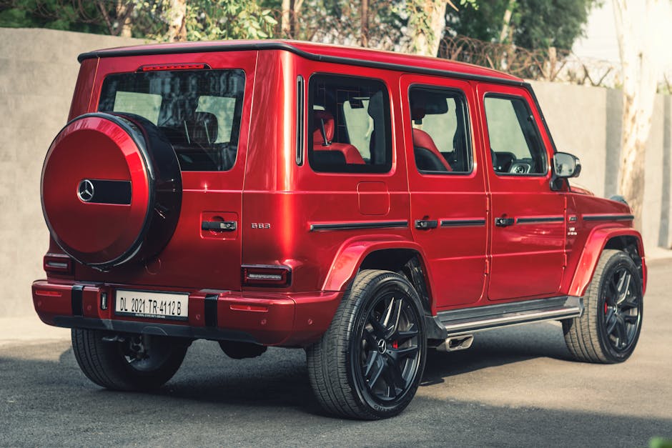 Elegant red SUV Mercedes-Benz G Class parked outdoors, showcasing luxury and sophistication.