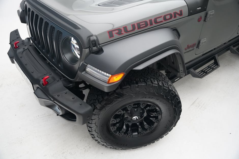High angle view of a Jeep Rubicon SUV showcasing tire and front design on a white backdrop.