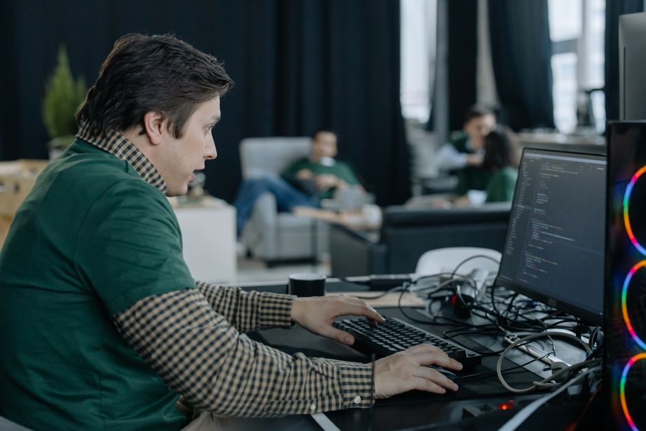 Programer koncentrirano kodira na računalu u suvremenom uredu.